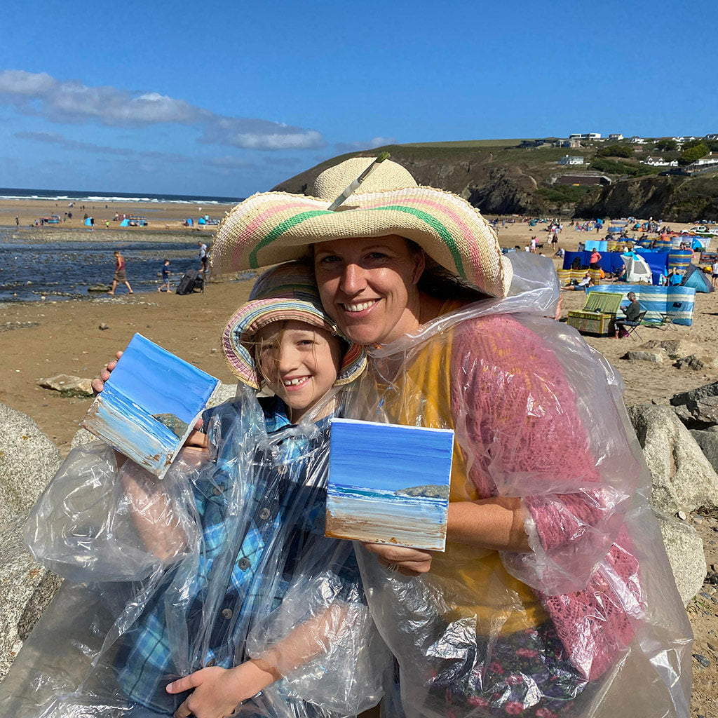 Mother and daughter painting together in the sunshine